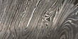 © nndanko - Detailed close up of damascus steel, showcasing its characteristic wavy and layered pattern of light and dark metal.
