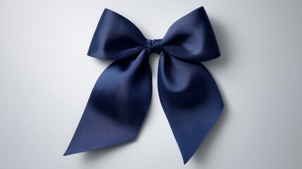Poster - A satin navy-blue gift bow with unique asymmetrical tails is elegantly placed on a light gray backdrop, casting crisp shadows that enhance its texture