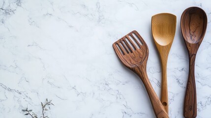 Poster - A set of cooking utensils including a wooden spoon, spatula, and ladle placed on a light-colored countertop with space above for copy
