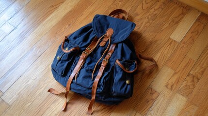 Poster - A close-up view of a navy blue backpack with durable straps rests on a smooth wooden table, illuminated by soft natural light, featuring a muted green background