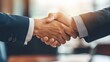 © Sim - Two professionals sealing a deal with a handshake in an executive suite.