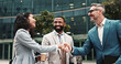 © peopleimages.com - Happy, business people or handshake in city for greeting, meeting or partnership in urban town. Shaking hands, smile or financial advisor with manager for B2B deal, introduction or recruitment offer