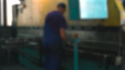Fototapete - Precision work on a press brake in a bustling manufacturing facility