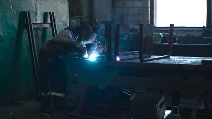 Poster - Welder crafting metal components in a vibrant workshop environment