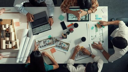 Poster - top view of smart architect engineer writing at blueprint while sitting at meeting table with house 