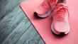 © Gulnaz - A pair of pink sneakers are on a pink mat