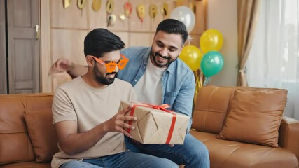 Poster - Two friends or family members sharing a moment with a wrapped present.