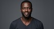 © LittleDuck - Confident Black Man Portrait - A friendly, smiling Black man in a dark v-neck shirt against a gray background. Perfect for diversity and inclusion projects