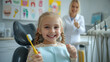 © Ariwasabi - Young girl smiling in dentist chair holding toothbrush as dentist gives thumbs up in brightly lit dental clinic. Image made using Generative AI.