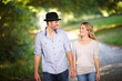 © peopleimages.com - Couple, hand holding and happy with walk in park for love, bonding with care and support in healthy relationship. Man, woman and outdoor for date with romance, trust and commitment for marriage