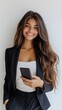 © Kagami - Smiling woman in business attire holding a phone