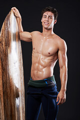 studio, fitness and male surfer with board, hobby and athlete isolated on black background. portrait