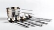 © Nayyar - Shiny Stainless Steel Kitchenware: A Stack of Three Sauce Pans with Long Handles and a Row of Matching Serving Spoons Arranged Neatly on a Plain White Surface, Reflecting Modern Culinary Tools.
