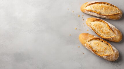 Poster - Golden crusted French baguette is placed diagonally on a seamless light backdrop, enhanced with subtle crumbs that add an artisanal touch and rustic appeal