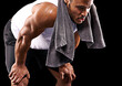 © peopleimages.com - Fitness, relax and man in studio with towel, sweat and exhausted commitment to muscle workout. Air, rest and tired athlete on black background for exercise, breathing and fatigue in morning training.