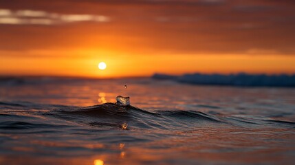 Poster - Glistening amber droplet leaps from a soft wave as the sun sets on the horizon, casting warm hues on the tranquil ocean surface and blurred background