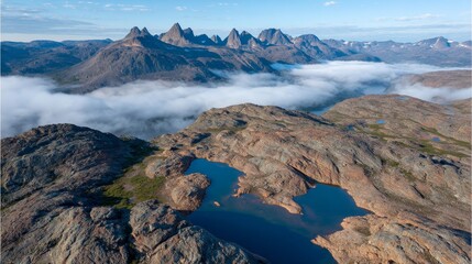 Aufkleber - A breathtaking alpine landscape features a serene pond that mirrors rugged mountain peaks at sunrise, enveloped by soft fog lingering at the shoreline