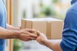 © Mas - a man's hand receiving a delivery package from a young male courier in a blue shirt at the door