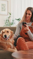 Fototapete - Sofa, woman and dog with smile for mobile, online research and application for pet insurance. Home, animal and golden retriever with female person for smartphone, social media and relax in lounge