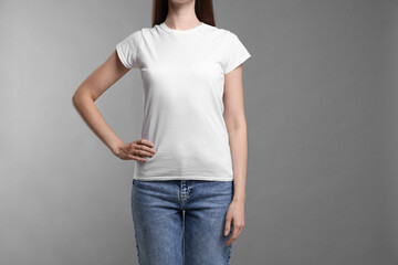 Wall Mural - woman wearing blank white t-shirt on light grey background, closeup. mockup for design