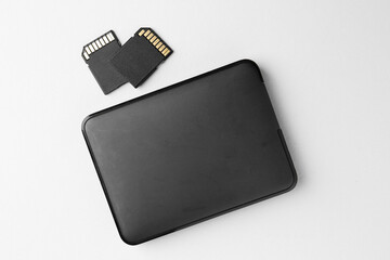Poster - External hard drive and SD memory cards on white background, flat lay