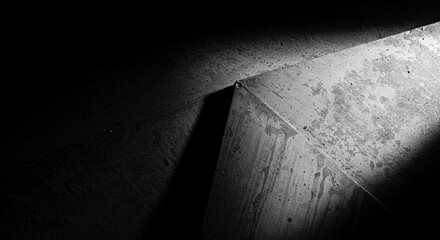 Poster - A black and white photo of a concrete floor with a shadow of a triangle