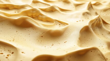 Poster - Close-up view of textured golden foam resembling sand dunes, with soft shadows and highlights