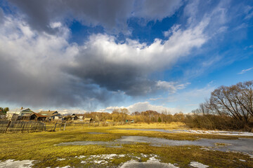 Wall Mural - a cloudy sky with a few houses in the background