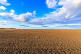 A field of dirt with a blue sky in the background