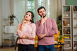 © StockImageFactory - Indian couple standing at home with confused expressions, thinking about decision or problem