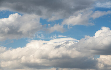 Wall Mural - blue sky with fluffy white close up clouds.