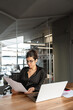 © Stock 4 You - Focused latin or arabian young business woman hr working on laptop computer reading finance document report in office. Accountant saleswoman manager businesswoman doing paperwork using pc. Vertical