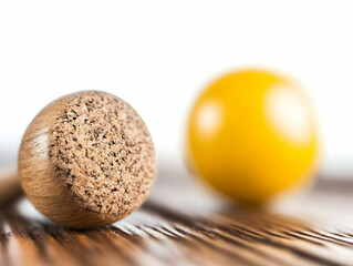 Fototapete - Wooden Textured Sphere Next to Blurred Yellow Sphere on Wooden Surface Macro Shot