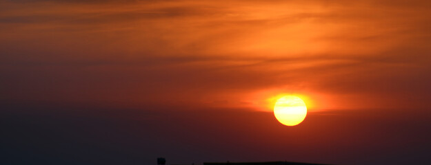 Wall Mural - Sun against the background of red clouds.