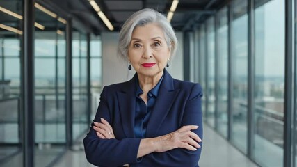 Poster - Businesswoman stands confidently with arms crossed, wearing a blue suit.