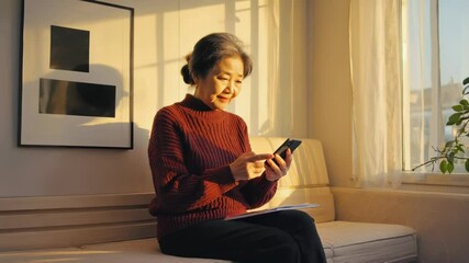 Aufkleber - Woman relaxing on a couch while using her cell phone.