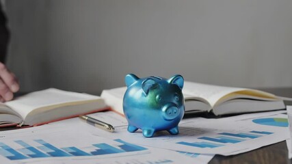 Poster - A person adds coins to their savings jar.