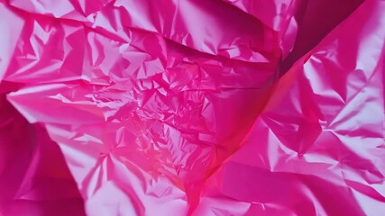 Poster - The shot captures a close-up view of crumpled vibrant pink paper, displaying intricate folds and creases that create a textured appearance under natural light.