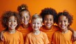 © miss irine - Diverse group of happy children wearing orange shirts. Smiling faces, friendly hugs, look at camera. Kids cheerful, celebrate unity, friendship, diversity. Bright orange backdrop creates positive