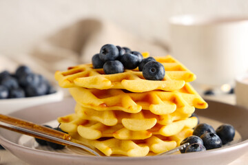 Wall Mural - delicious belgian waffles with blueberries in plate on table against white background