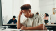 © peopleimages.com - Anxiety, computer and headache with designer man in office for project or reporting deadline. Frustration, stress and web development with small business employee in creative startup for solution