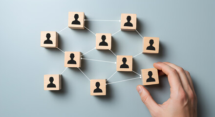 Poster - Conceptual Wooden Cubes Representing a Network of People with Hand Placement on Gray Background
