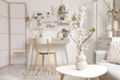 © Pixel-Shot - Vase with blossoming branches on table in light office