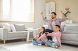 © Pixel-Shot - Happy father with his little children playing video game at home