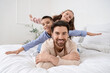 © Pixel-Shot - Happy father with his little children lying in bedroom