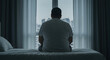 © abu - Silhouette of a Man Sitting on Bed with Pills Overdose Contemplating Tragedy and Mental Health Crisis Near Window