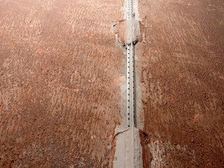 Poster - A cracked and worn concrete floor with a metal bar sticking out of it