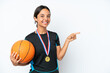 © luismolinero - Young basketball player woman isolated on white background pointing finger to the side