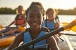 © Iryna - Smiling african young girl kayaking with friends on sunny lake
