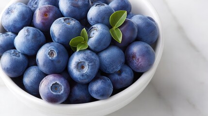 Poster - Fresh blueberries cascade in abundance within a clean white bowl on a marble countertop